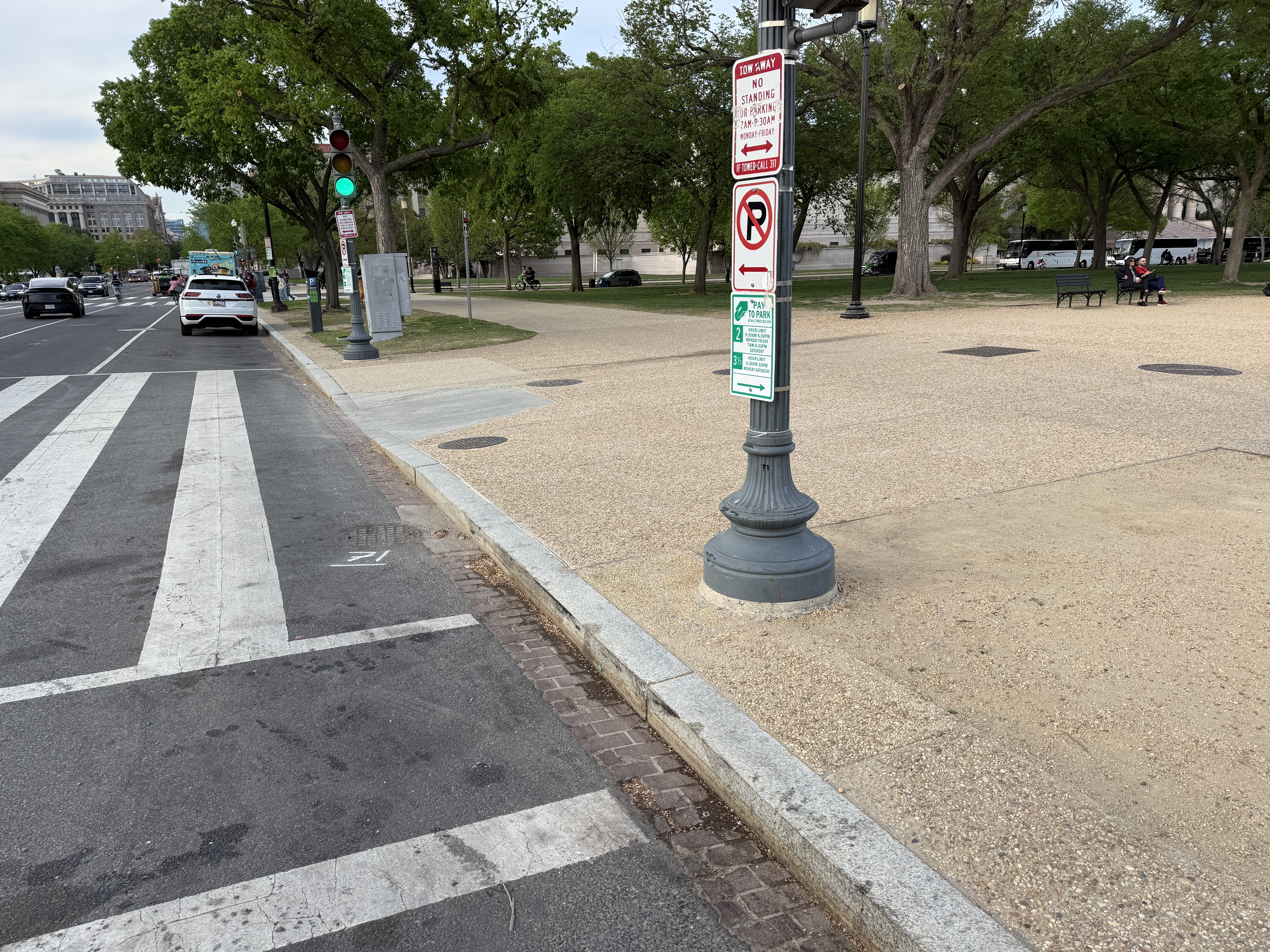 Corner pole at the south edge of the National Mall on 7th St SW carries a green Pay to Park sign authorizing 2-hour and 3-hour paid parking, with a Tow Away / No Standing or Parking restriction that applies only 7AM-9:30AM Monday-Friday. Outside those peak weekday hours, DDOT signage authorizes parking right up to this high-volume tourist crosswalk.